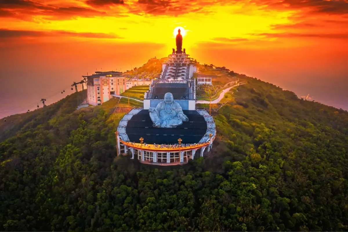Tượng Phật trên đỉnh núi trong ánh hoàng hôn vàng cam